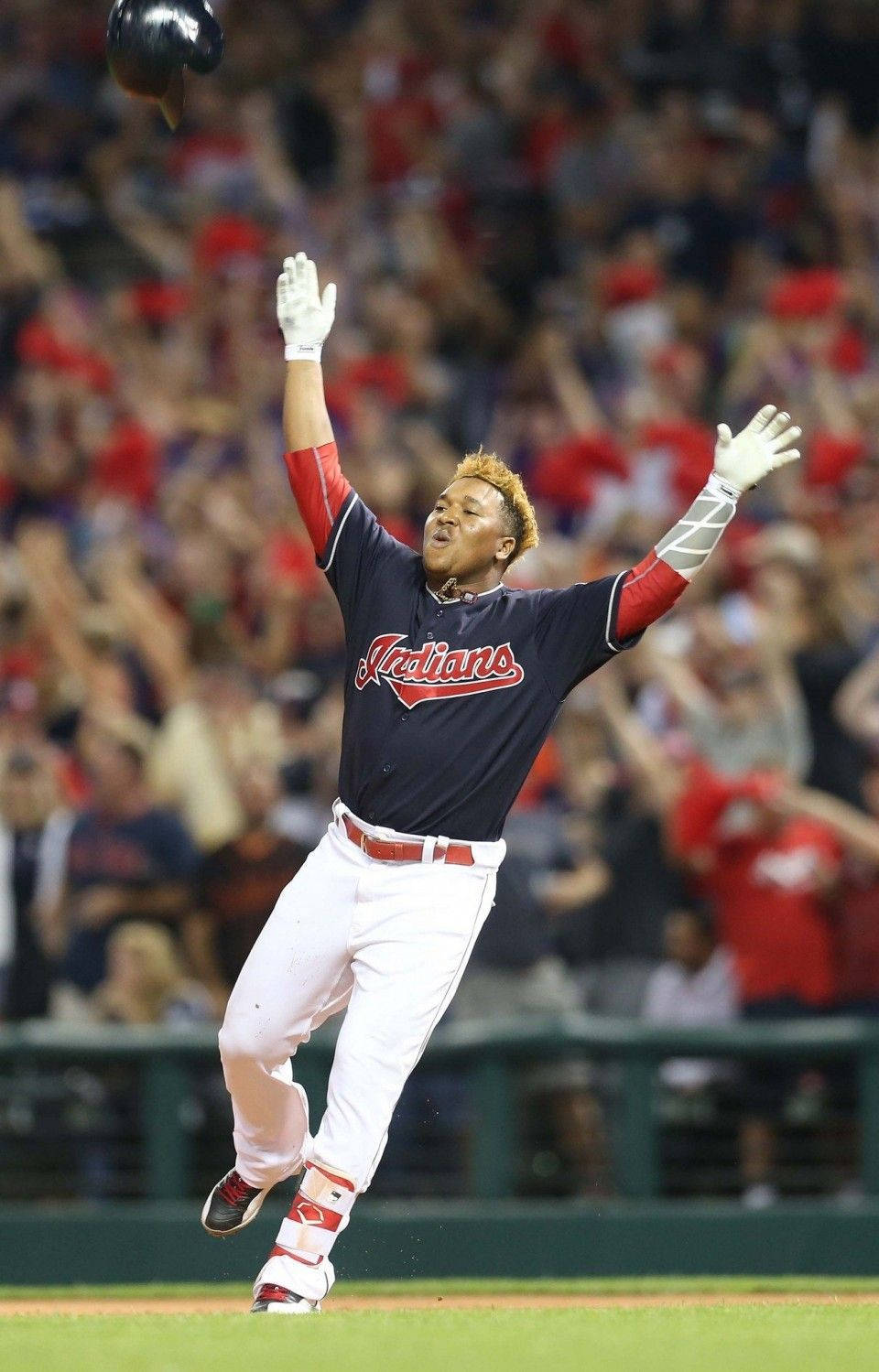 Jose Ramirez 桌布 壁紙 — 一名身穿深藍色印第安人隊球衣的棒球選手在夜間比賽中，高舉雙臂、頭盔拋向空中，歡欣跳躍。