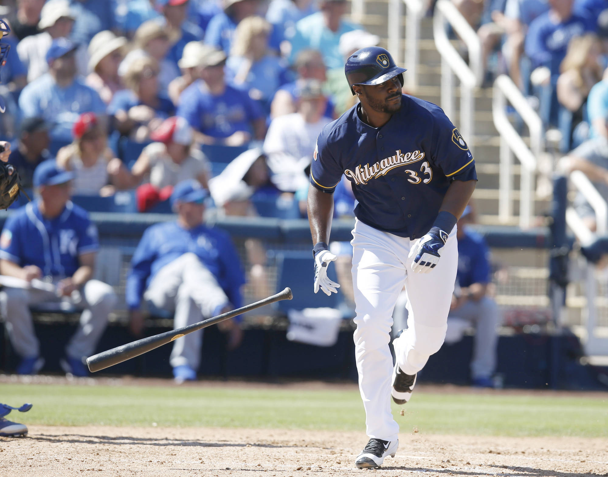 Brewers 桌布 壁紙 — 一名身穿深藍色球衣的密爾瓦基釀酒人棒球選手，在擊出全壘打後決心奔跑，球棒在空中飛舞，身後的球場觀眾為他歡呼。