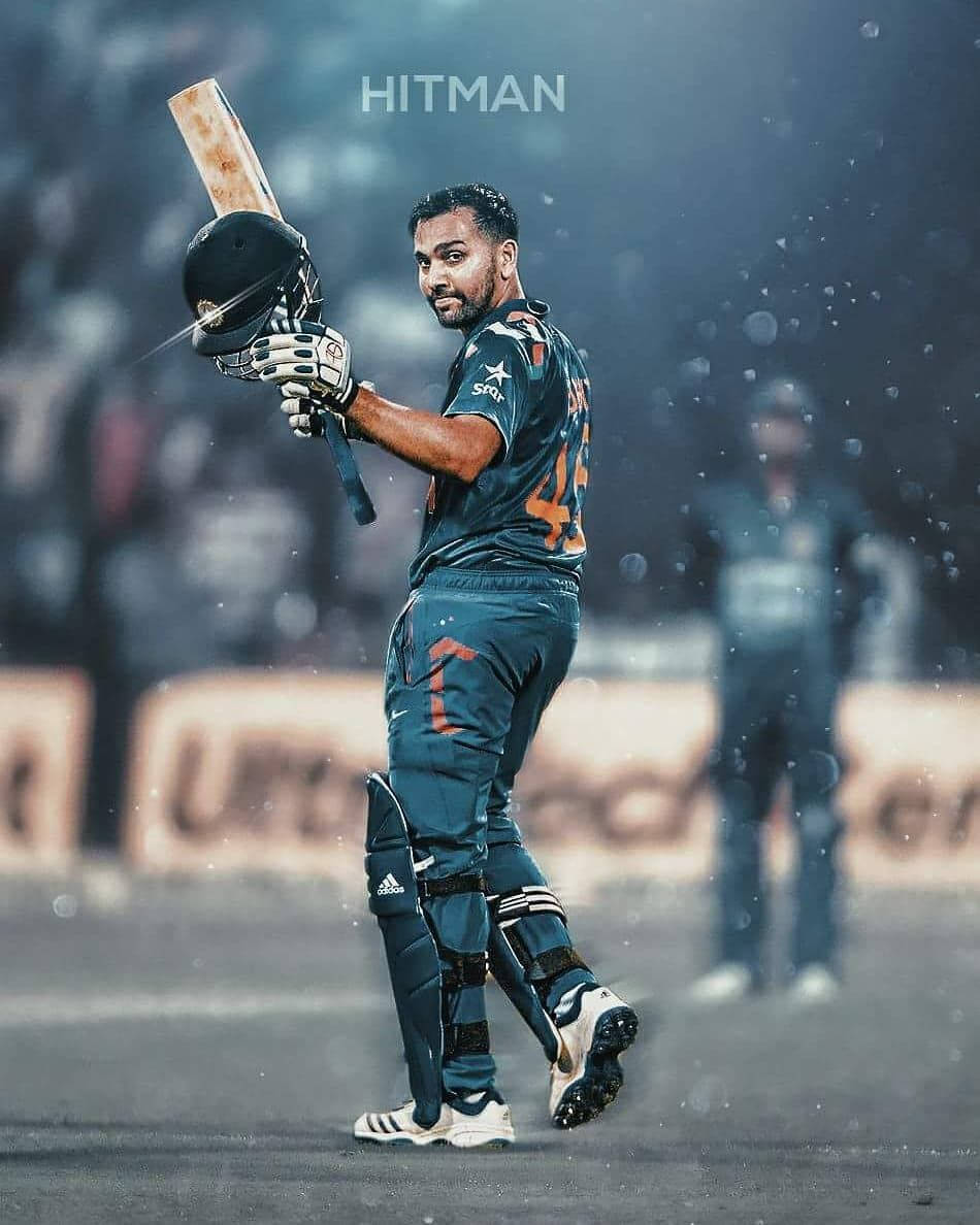 Rohit Sharma 桌布 壁紙 — 一名身穿深藍色球衣的板球運動員在濕滑的球場上高舉球棒和頭盔，慶祝勝利。