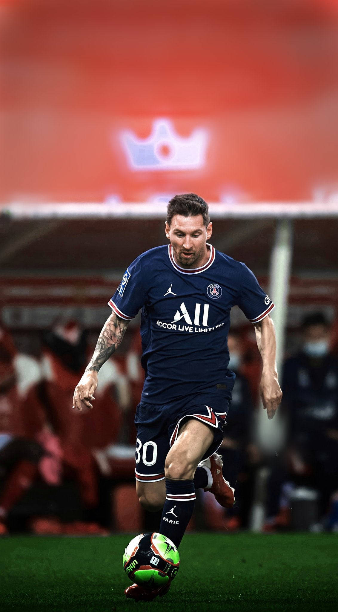 Messi 4K Ultra HD 桌布 壁紙 — 一名身穿深藍色球衣的足球運動員在球場燈光下，於翠綠的草地上盤球，球是鮮明的綠色和白色。