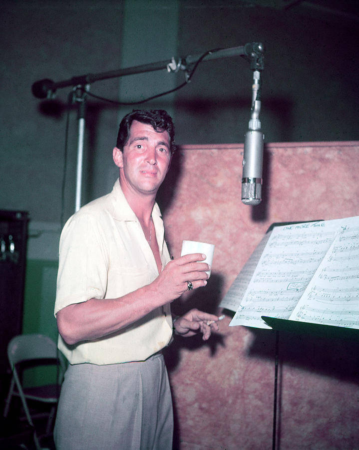 Entertainment 桌布 壁紙 — 一名身穿淺色襯衫的男子在復古錄音室中，手持杯子和香煙，旁邊有麥克風和樂譜。