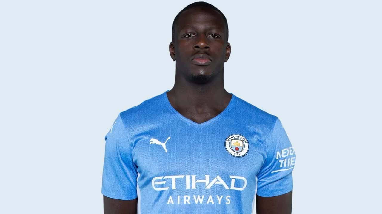 Mendy 桌布 壁紙 — 一名身穿淺藍色曼徹斯特城球衣的足球運動員站在純淺藍色背景前。