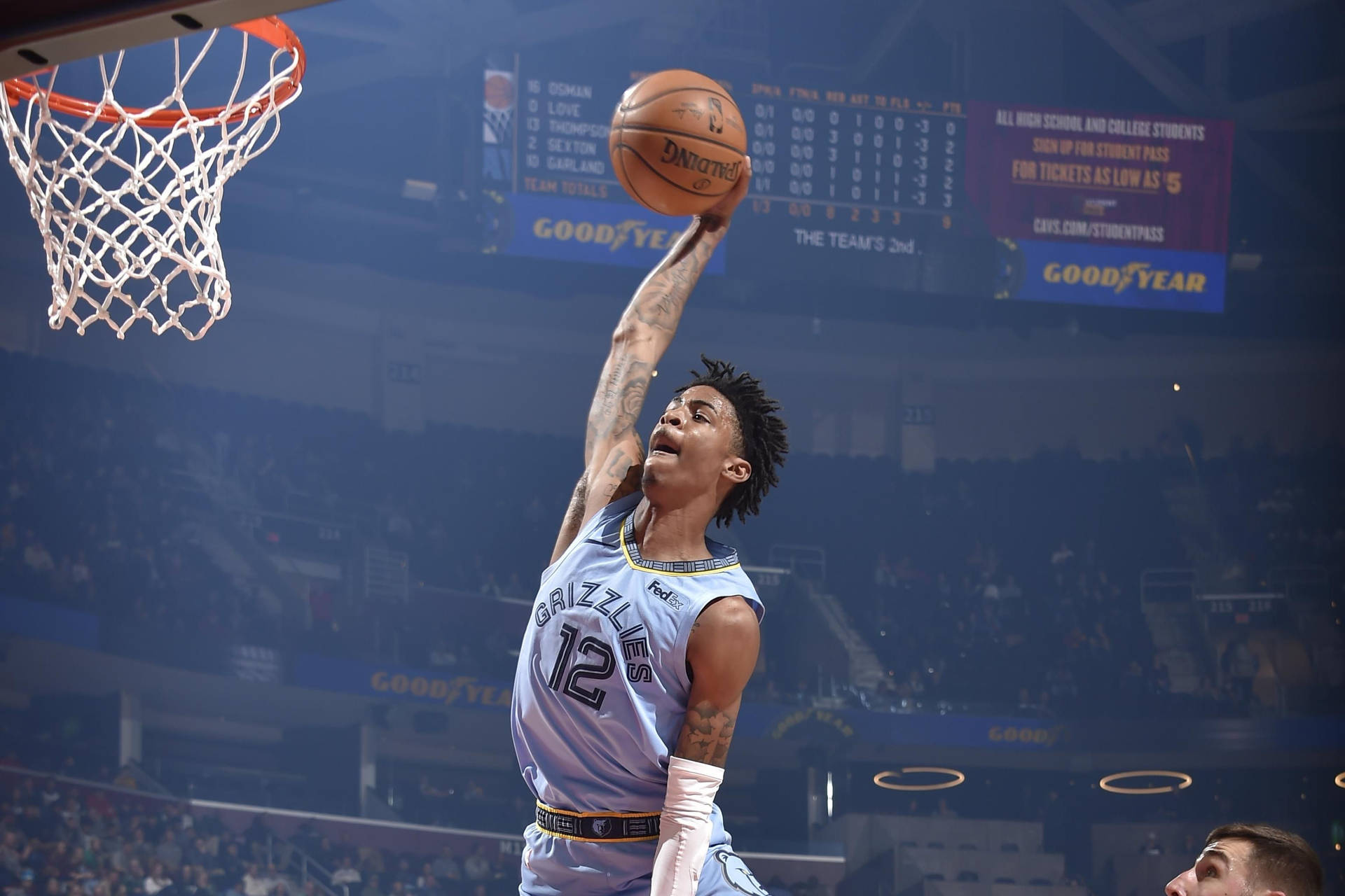 籃球運動員在擁擠的場館中灌籃，身穿淺藍色球衣。 — Ja Morant 動圖 壁紙