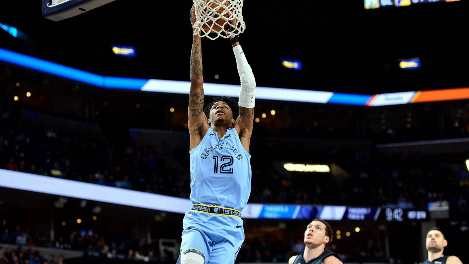 籃球運動員在夜間擁擠的場館中灌籃。 — Ja Morant 動圖 壁紙