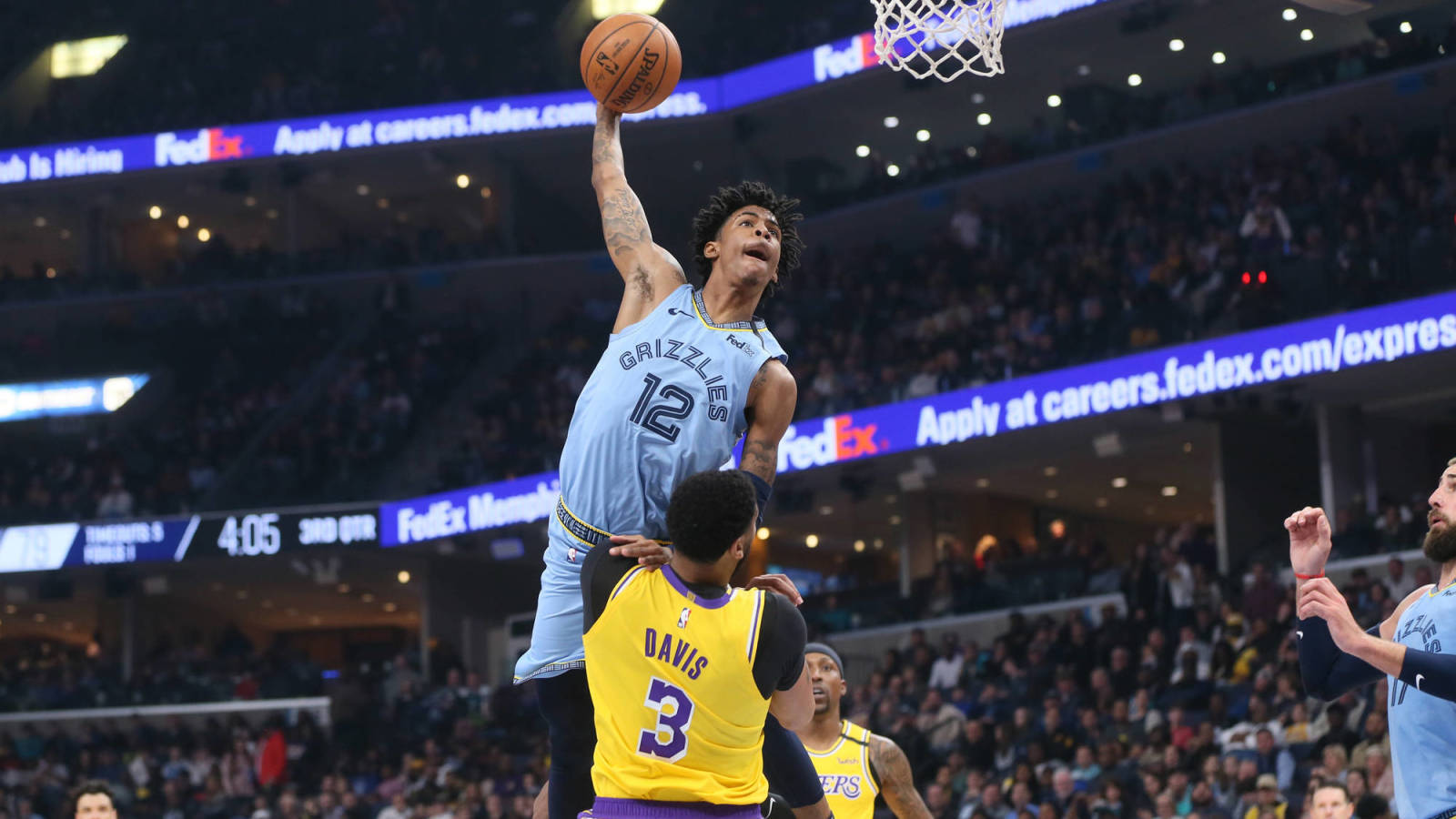 籃球運動員在座無虛席的場館內越過防守球員灌籃。 — Ja Morant 動圖 壁紙