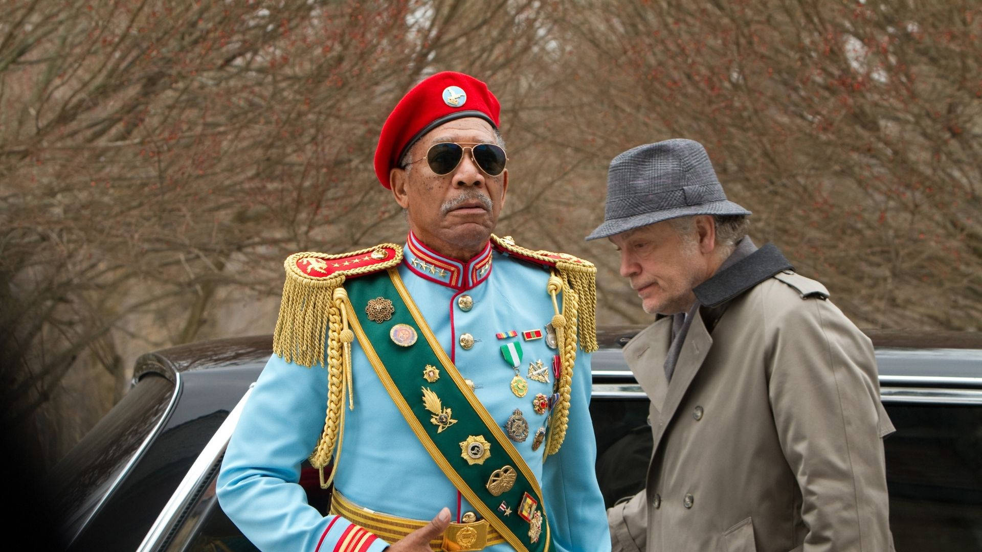 Morgan Freeman 桌布 壁紙 — 一名身穿淺藍色軍裝、金色肩章和紅色貝雷帽的男子，站在另一名身穿灰色大衣和帽子的男子旁邊，靠近一輛汽車。