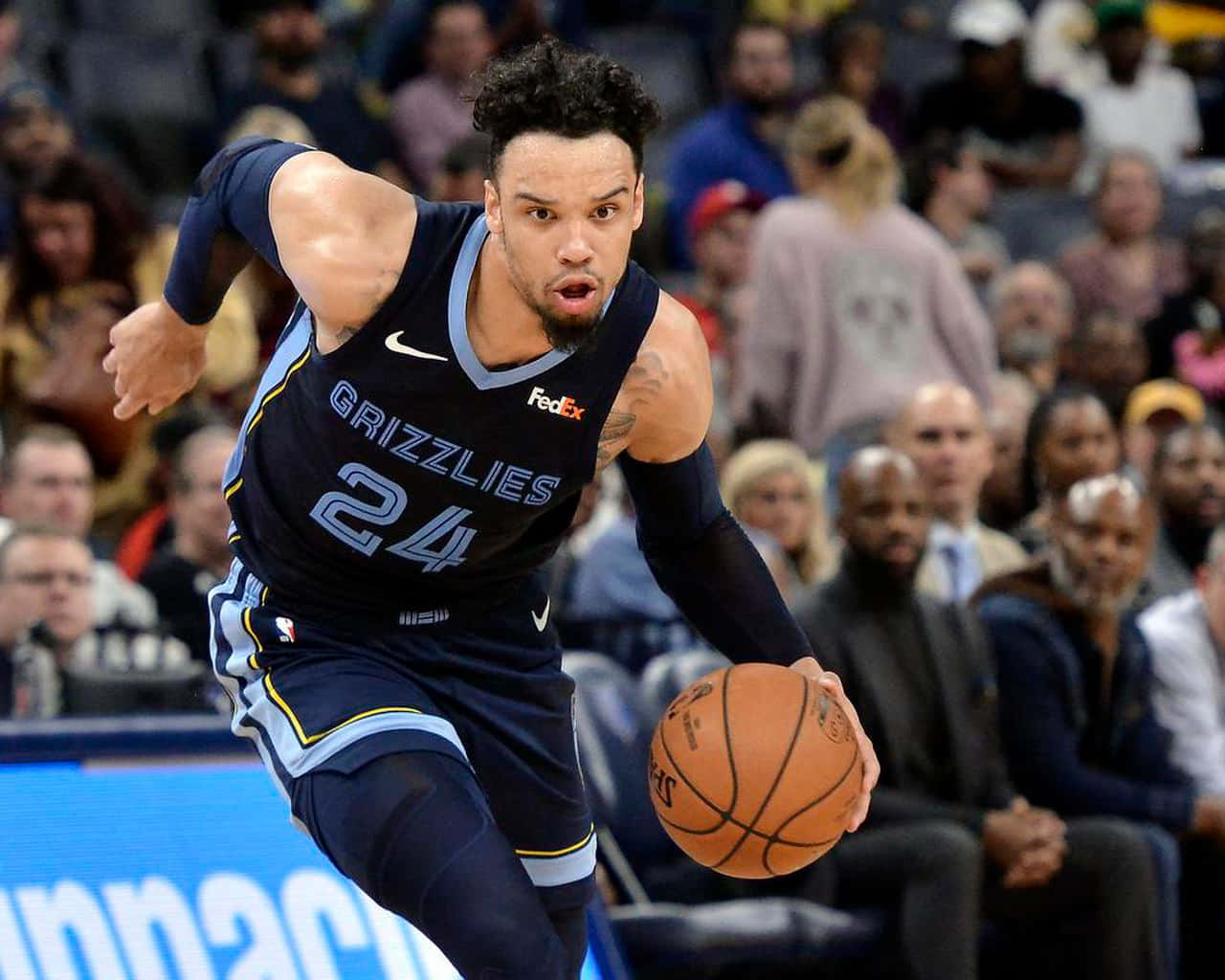 Dillon Brooks 桌布 壁紙 — 一名身穿灰熊隊球衣的籃球運動員在比賽中專注地運球，背景是模糊的人群。