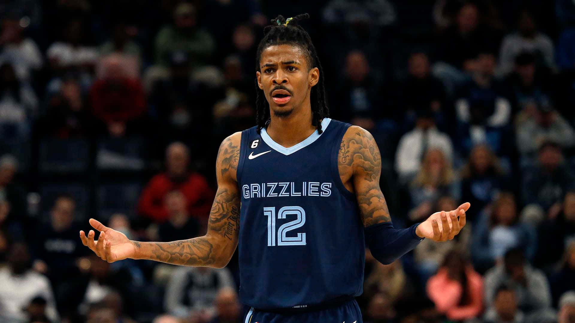Ja Morant 動圖 桌布 壁紙 — 一名身穿灰熊隊球衣的籃球運動員在比賽中做出沮喪的手勢，身後是模糊的人群。