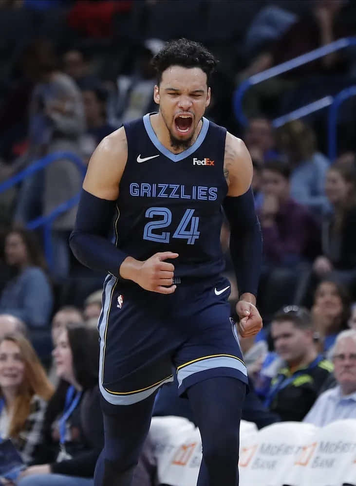 Dillon Brooks 桌布 壁紙 — 一名身穿灰熊隊球衣的籃球運動員在比賽中激烈咆哮，球迷們在觀眾席觀看。