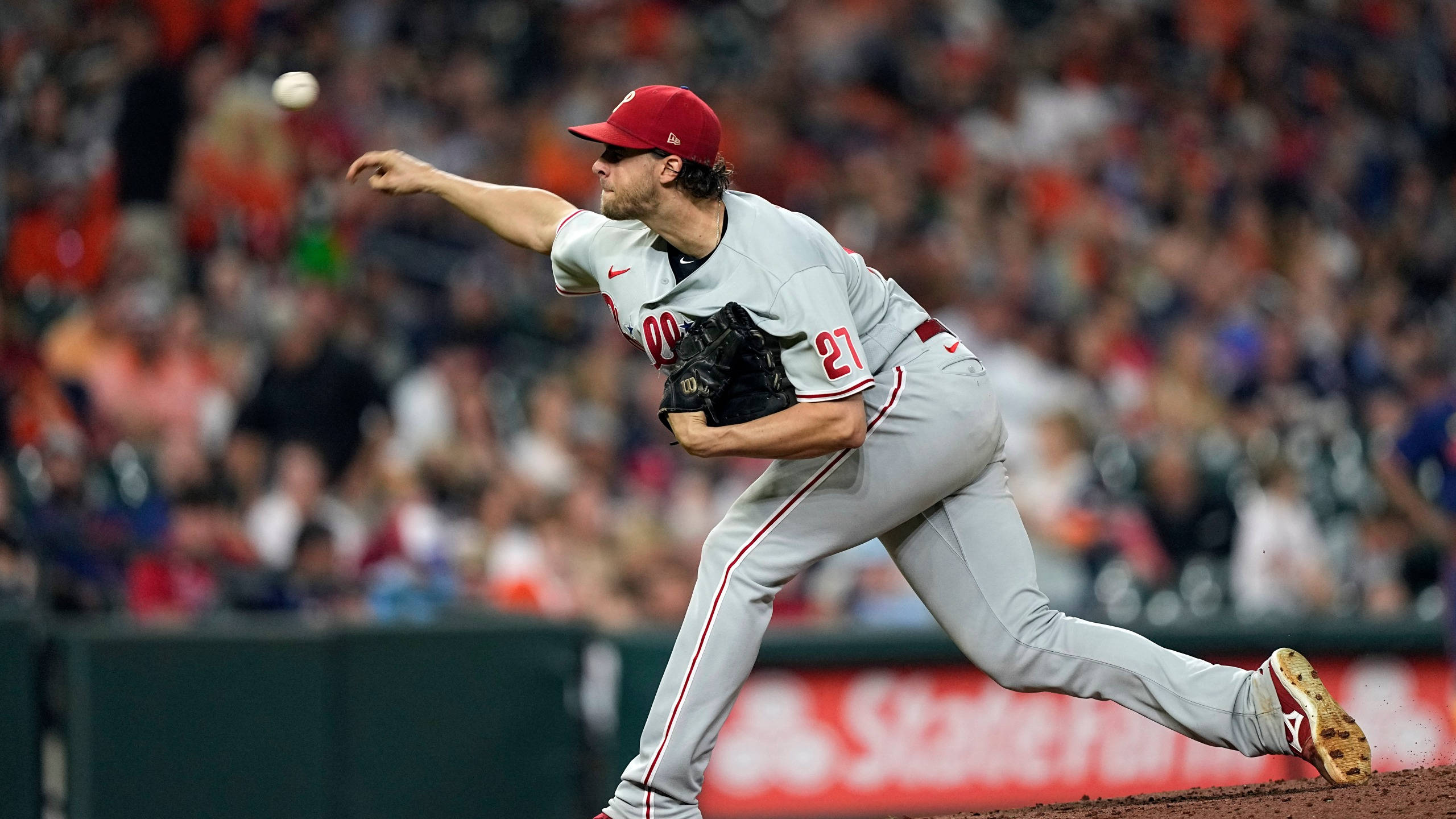 Phillies 桌布 壁紙 — 一名身穿灰色制服、戴紅色帽子、背號21的棒球投手，在模糊的人群前於投手丘上投球。