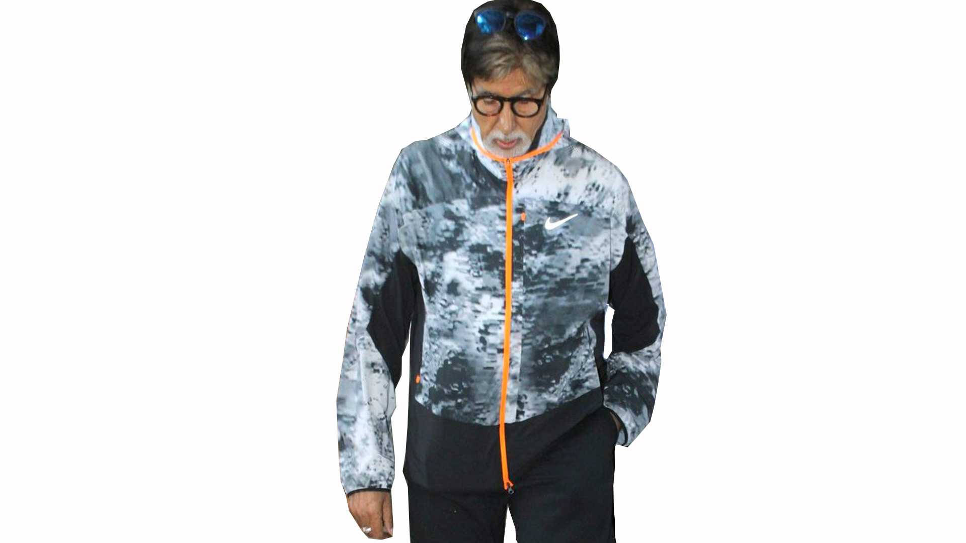 Amitabh Bachchan 桌布 壁紙 — 一名身穿灰色和黑色圖案外套、配有橙色拉鍊的男子站在純白色背景前。