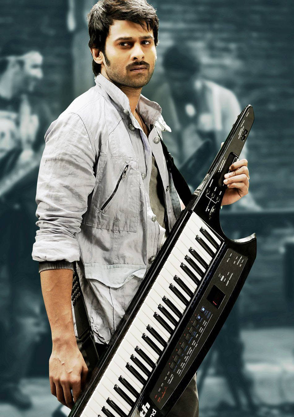 Prabhas Mirchi 桌布 壁紙 — 一名身穿灰色外套的男子，在模糊的城市背景下手持黑色鍵盤樂器，色調柔和。