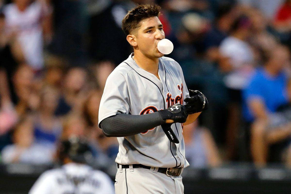 Nick Castellanos 桌布 壁紙 — 一名身穿灰色球衣的棒球選手在夜間比賽中吹出一個大泡泡糖，背景是模糊的球迷。