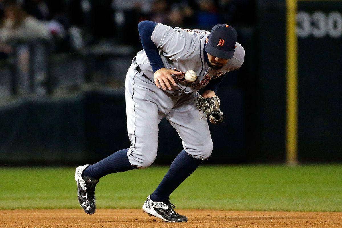 Nick Castellanos 桌布 壁紙 — 一名身穿灰色球衣的棒球選手在球場燈光下向前撲去接一個內野滾地球。