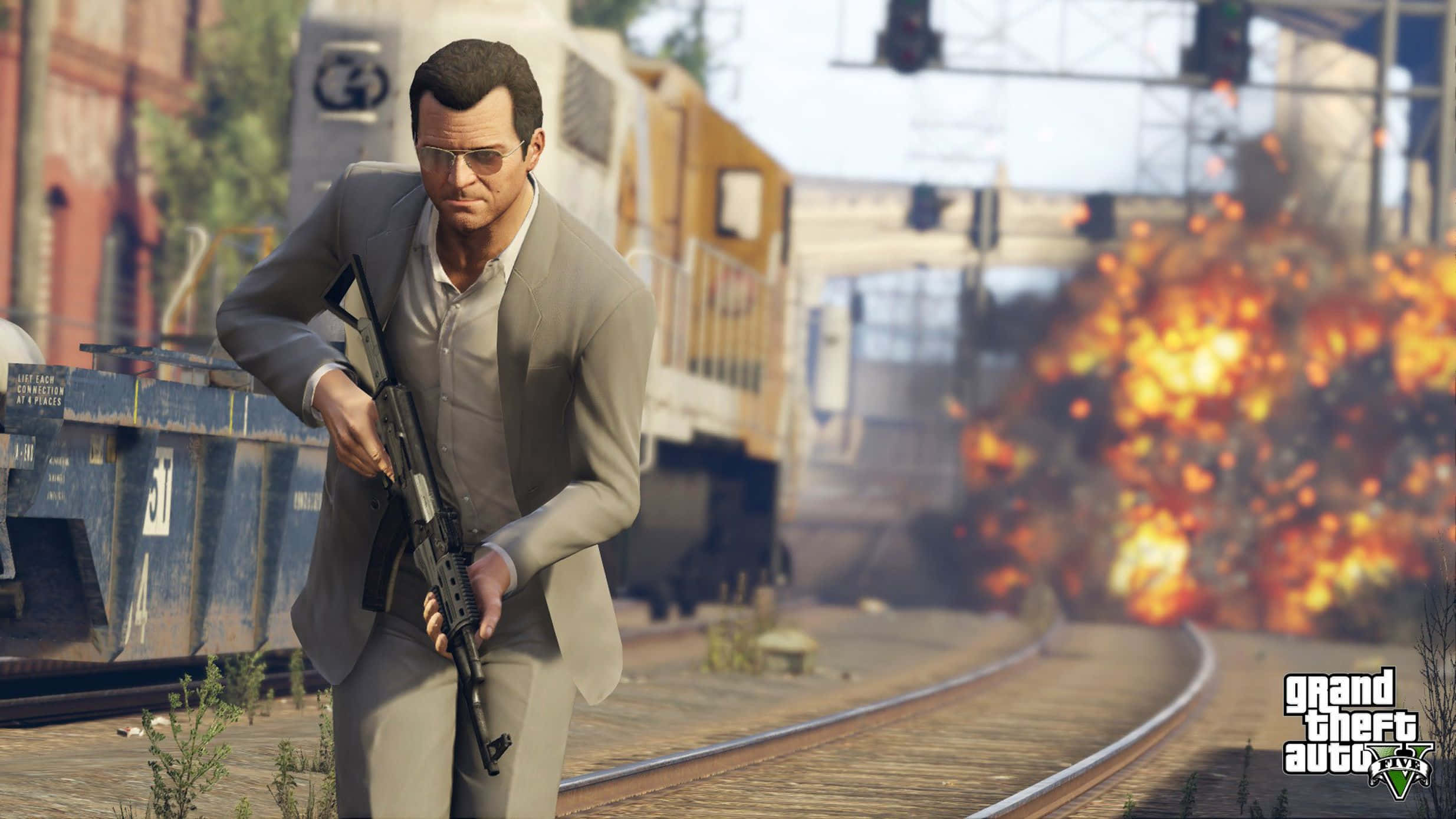 GTA 5 動圖 桌布 壁紙 — 一名身穿灰色西裝的男子在火車軌道附近手持突擊步槍，身後發生爆炸。