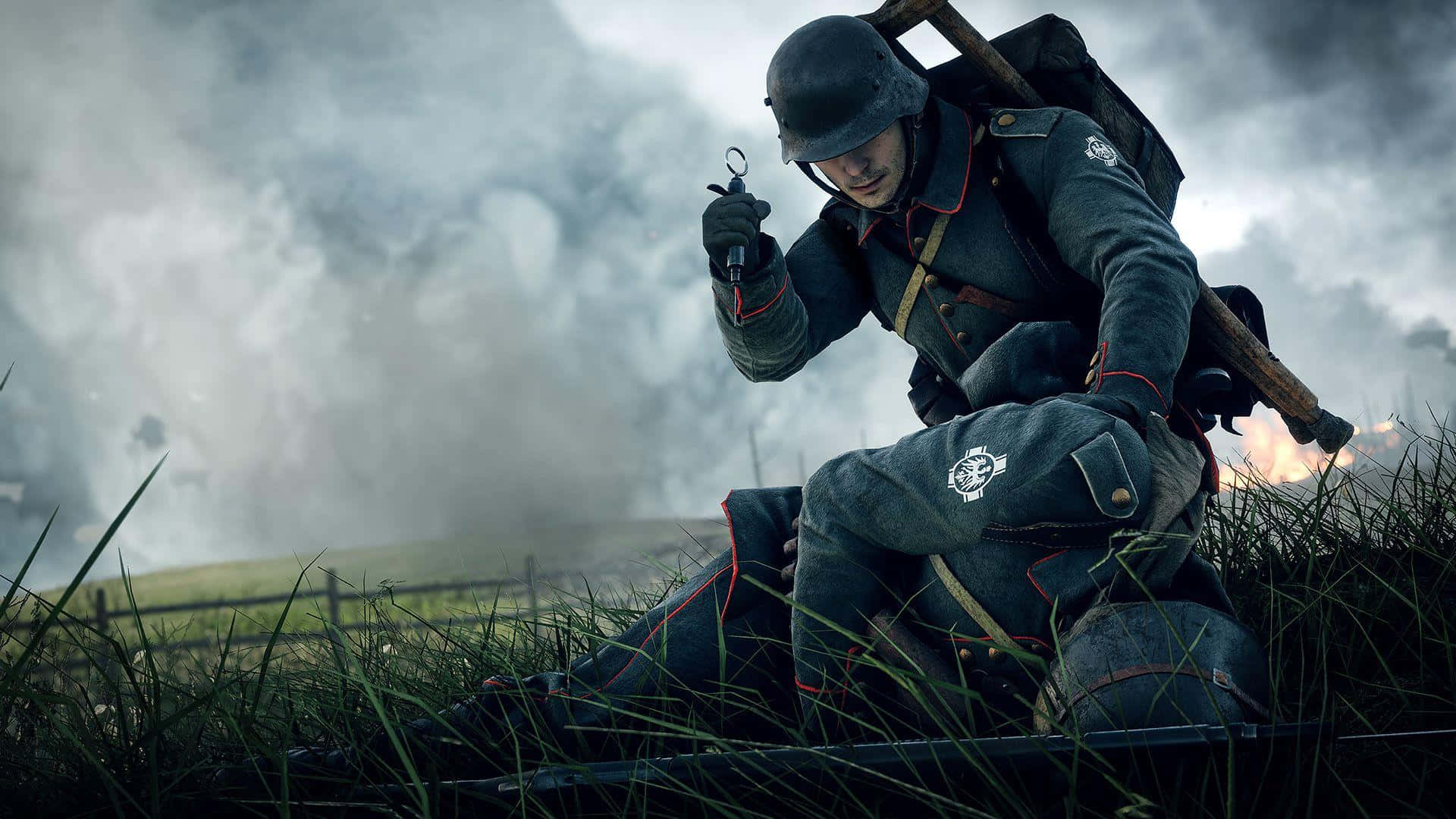 video games 桌布 壁紙 — 一名身穿灰色軍服的士兵蹲在草地上，手持手榴彈，身後煙霧瀰漫，天空多雲。