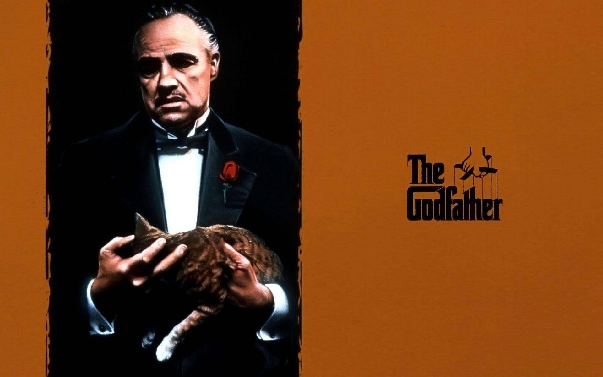Godfather 桌布 壁紙 — 一名身穿燕尾服的男人在鮮橙色背景上抱著一隻貓，並帶有「教父」標誌。