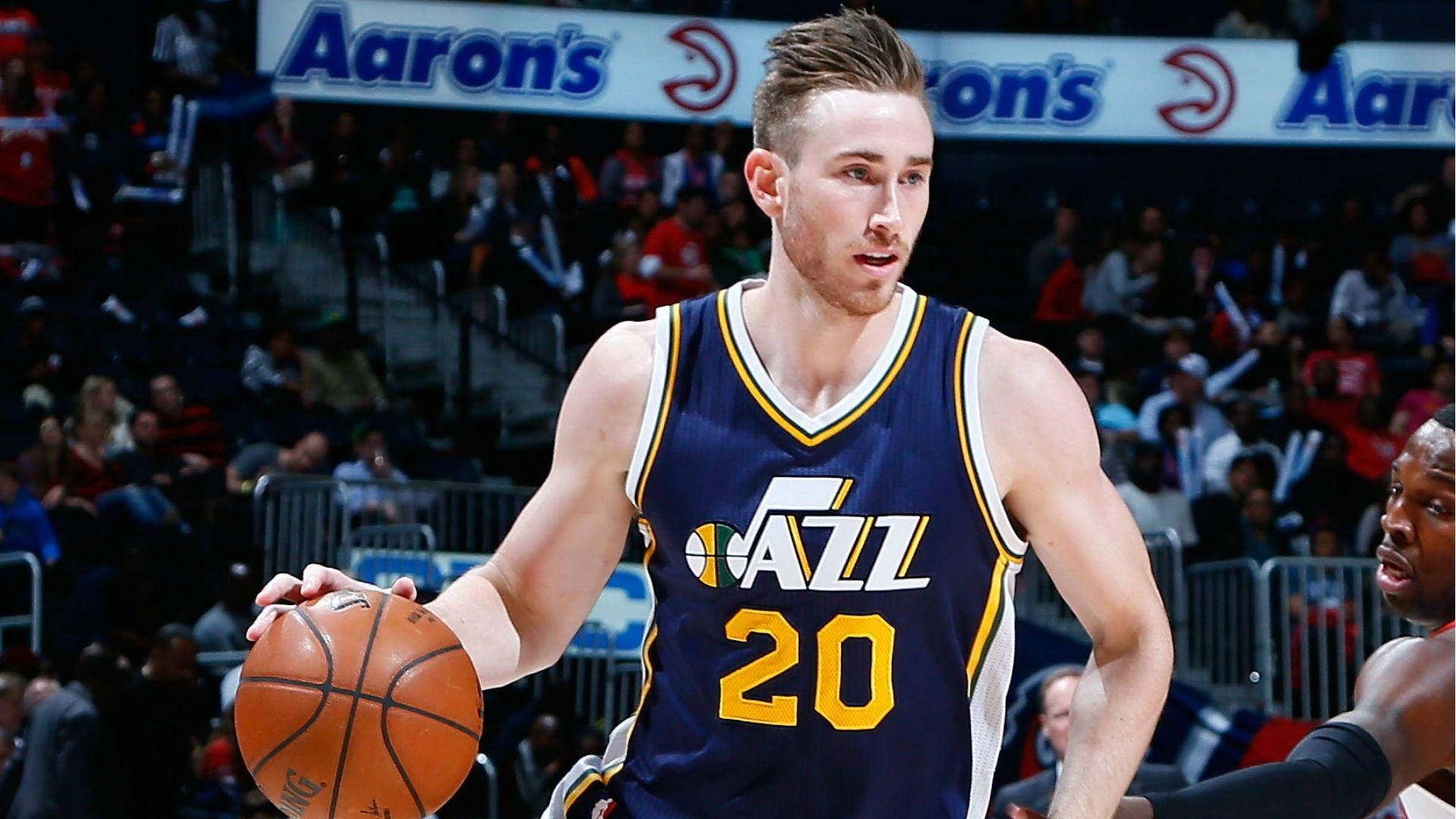 gordon hayward 桌布 壁紙 — 一名身穿爵士隊球衣的籃球運動員在明亮的場館燈光下，於激烈的比賽中運球。