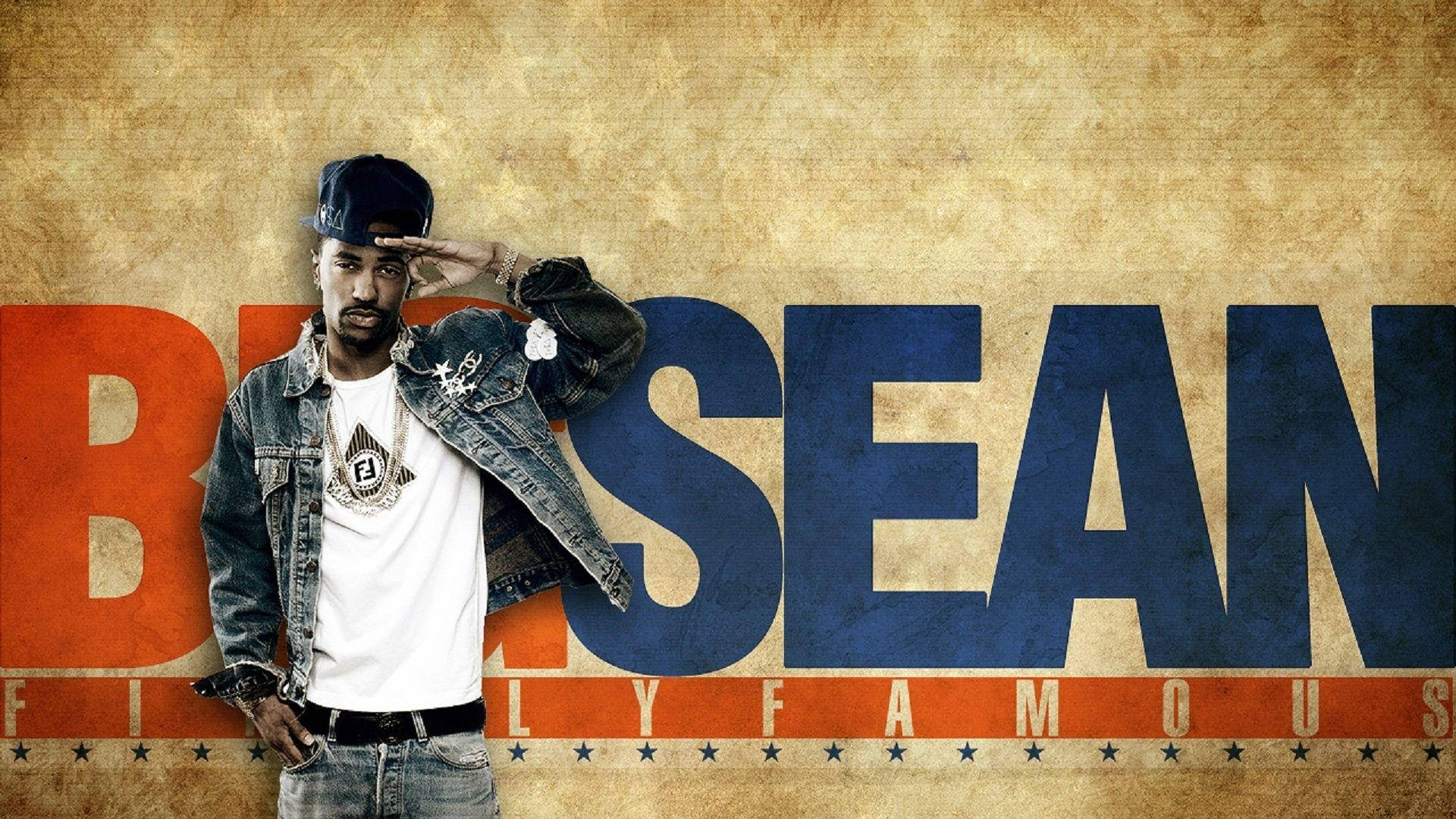 Big Sean 桌布 壁紙 — 一名身穿牛仔外套和帽子的男子，在帶有粗體橙色和藍色「BRISEAN」字樣的紋理背景前敬禮。