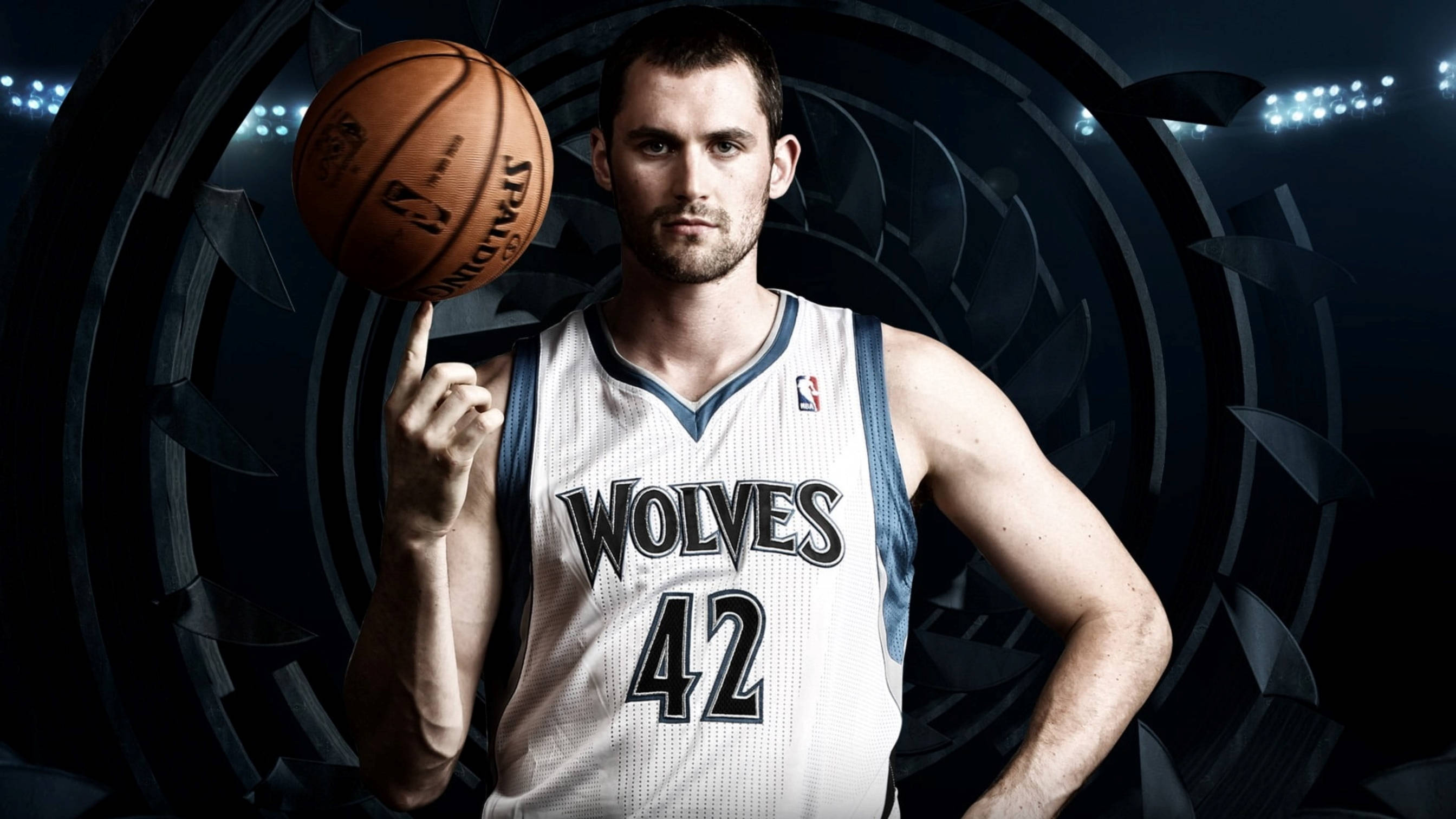 Kevin Love 桌布 壁紙 — 一名身穿狼隊球衣的籃球運動員在黑暗圓形體育場背景下，用手指平衡斯伯丁籃球。