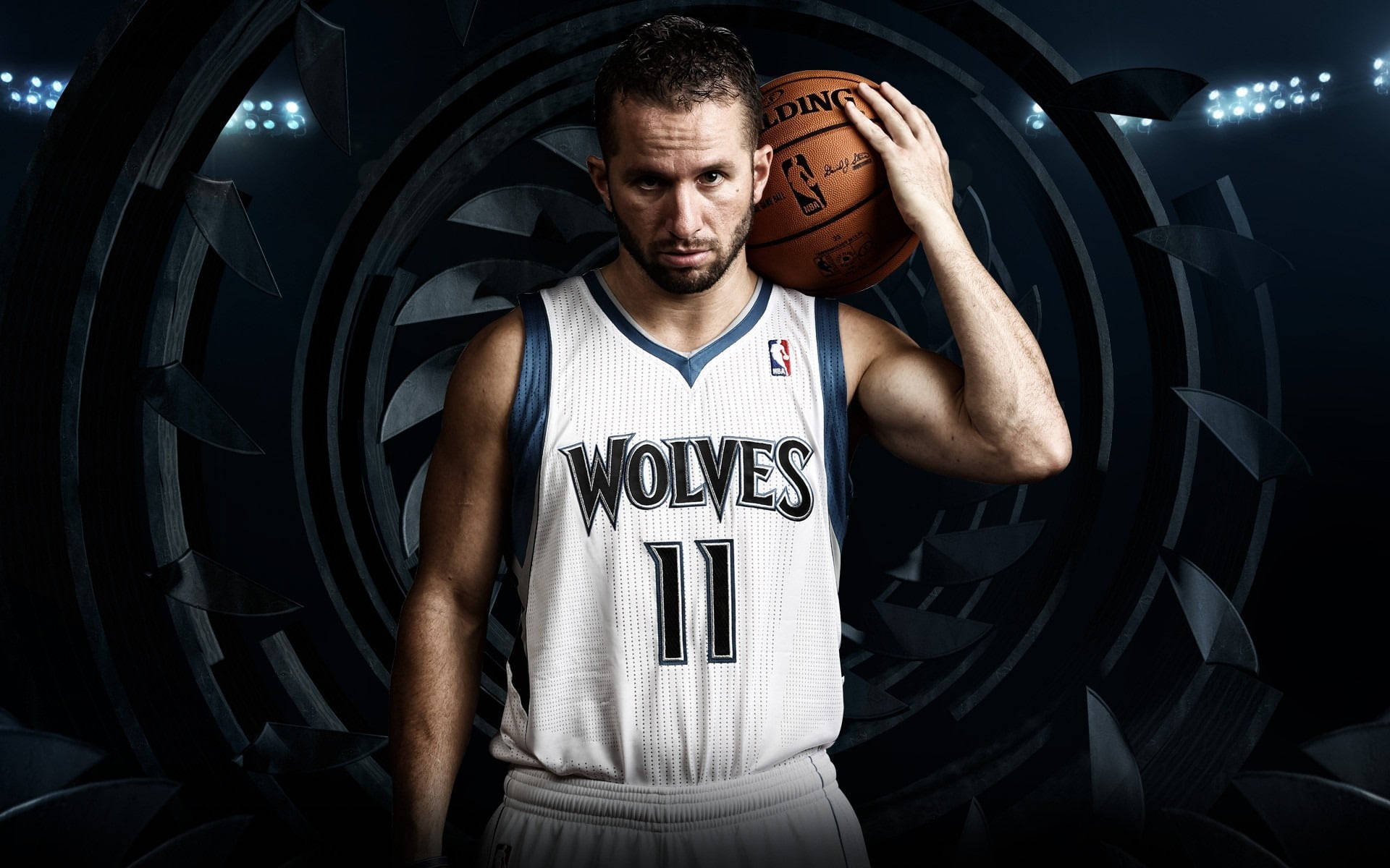 Timberwolves 桌布 壁紙 — 一名身穿狼隊球衣的籃球運動員在黑暗圓形體育場背景下，手持籃球，四周有明亮的聚光燈。