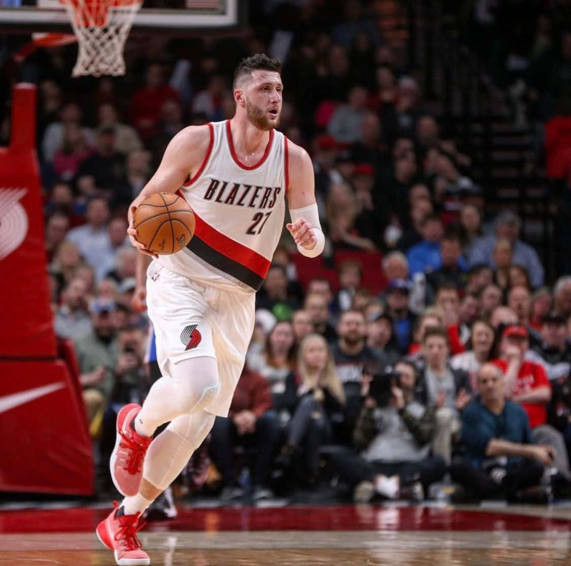 籃球 桌布 壁紙 — 一名身穿白色 Blazers 球衣的籃球運動員在激烈的比賽中運球，背景有觀眾。