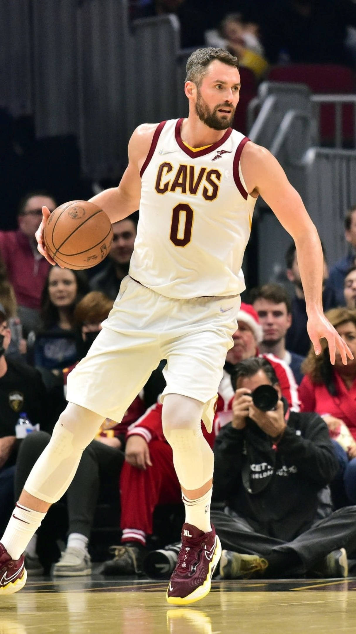 Kevin Love 桌布 壁紙 — 一名身穿白色 Cavs 球衣的籃球運動員在比賽中運球，背景有觀眾。