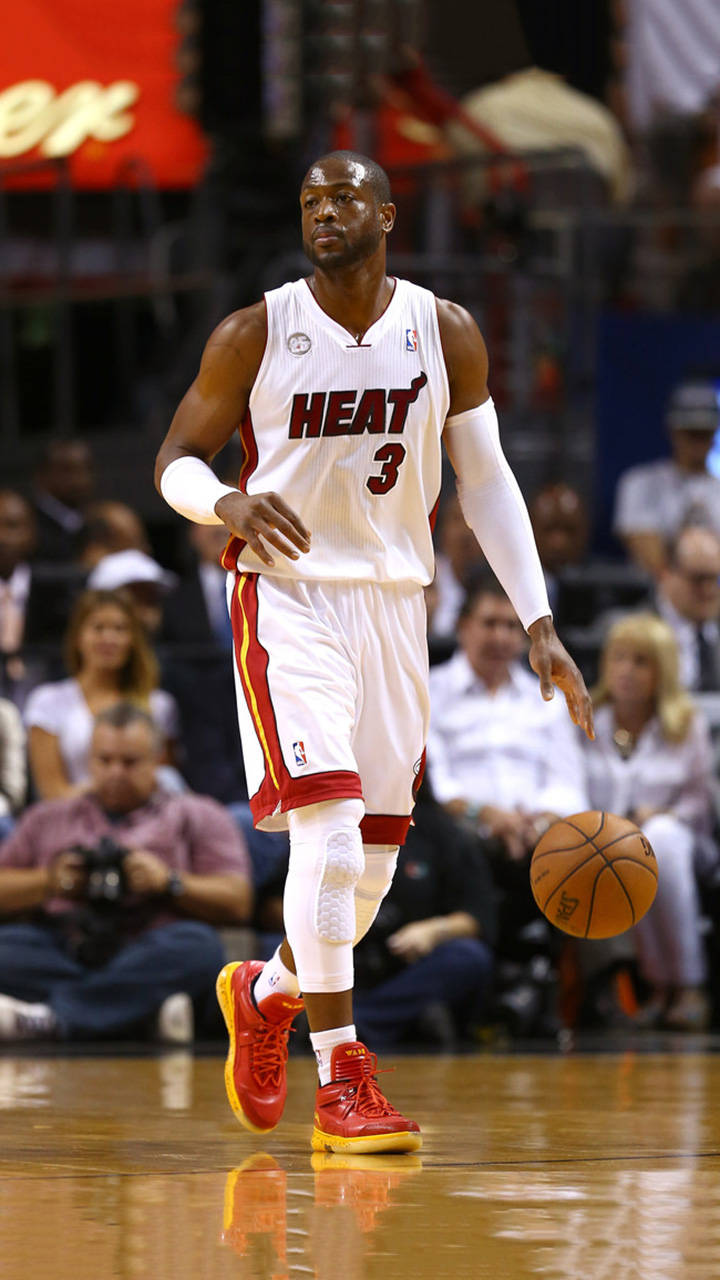 NBA 桌布 壁紙 — 一名身穿白色3號球衣的邁阿密熱火籃球運動員在體育館燈光下於拋光球場上運球。