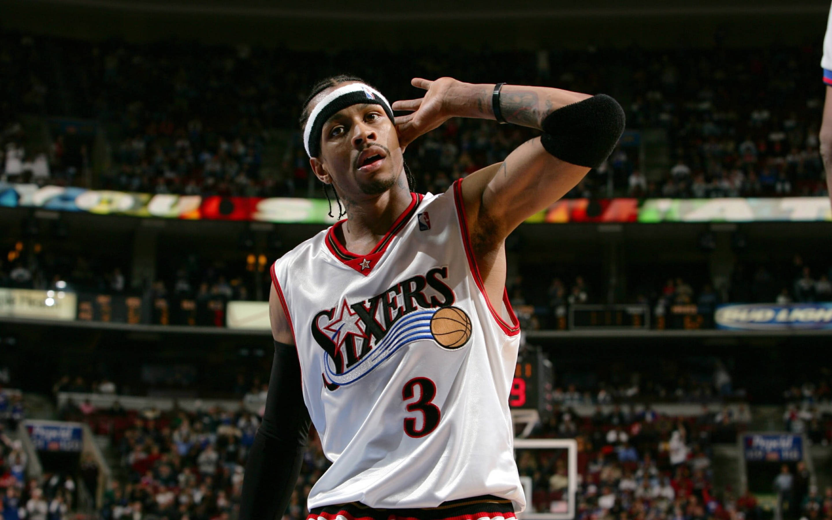 NBA 桌布 壁紙 — 一名身穿白色76人球衣、背號3號的籃球運動員，在準備投籃時用手遮擋明亮的場館燈光。