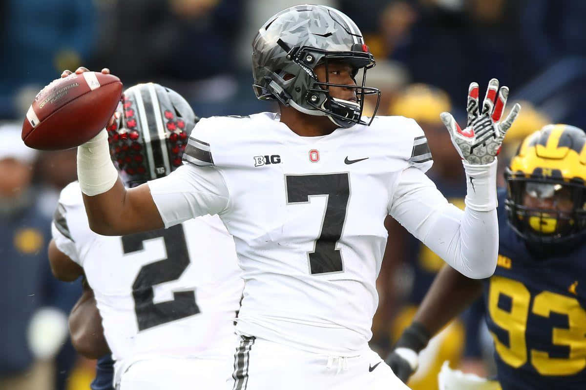 Dwayne Haskins 桌布 壁紙 — 一名身穿白色7號球衣的美式足球四分衛在比賽中傳球，隊友和對手都在焦點中。