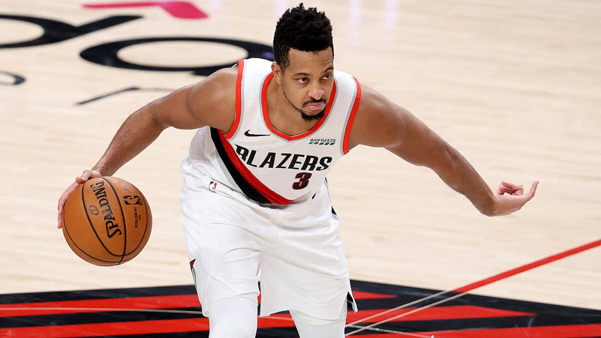 Cj 桌布 壁紙 — 一名身穿白色Blazers球衣的籃球運動員在硬木球場上專注地運球，球是Spalding牌。
