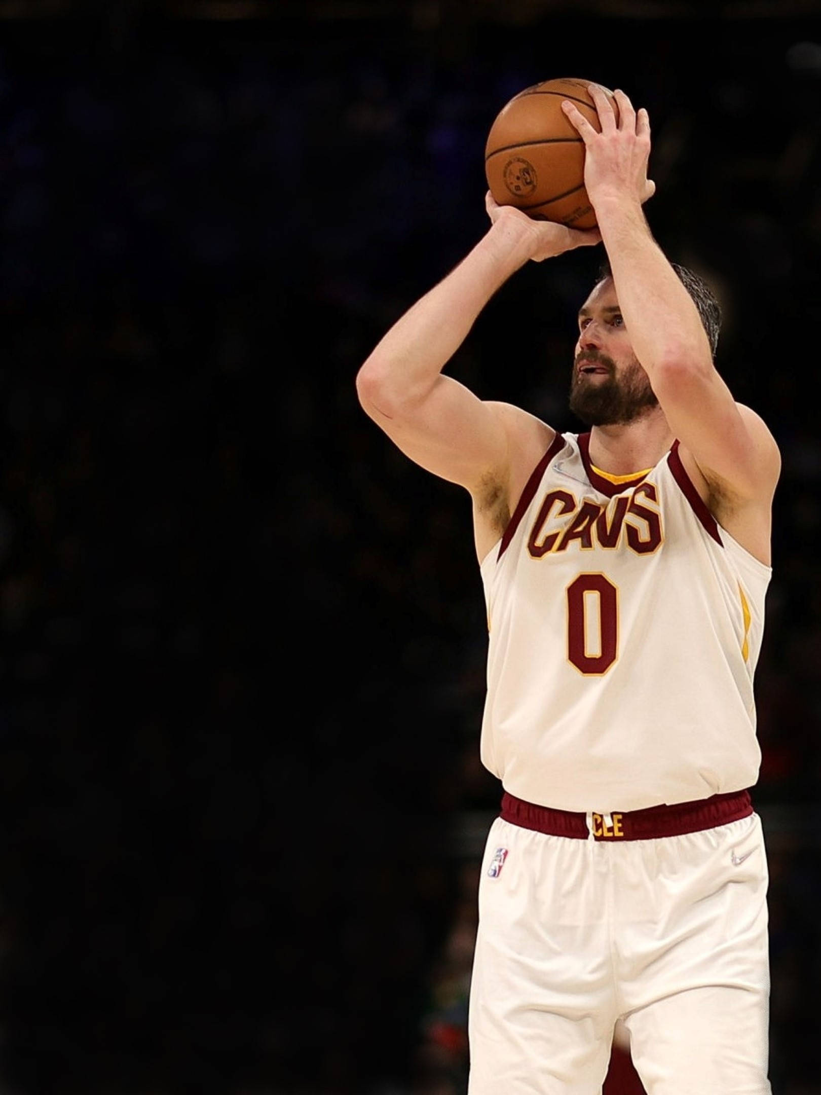 Kevin Love 桌布 壁紙 — 一名身穿白色Cavs球衣、號碼為零的籃球運動員在場館燈光下準備投籃。