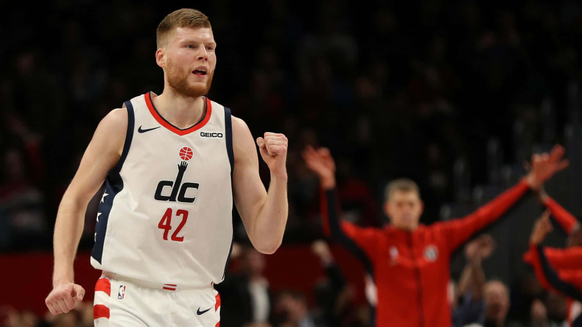 NBA 桌布 壁紙 — 一名身穿白色DC球衣、背號42的籃球運動員在明亮的場館燈光下比賽中握拳慶祝勝利。