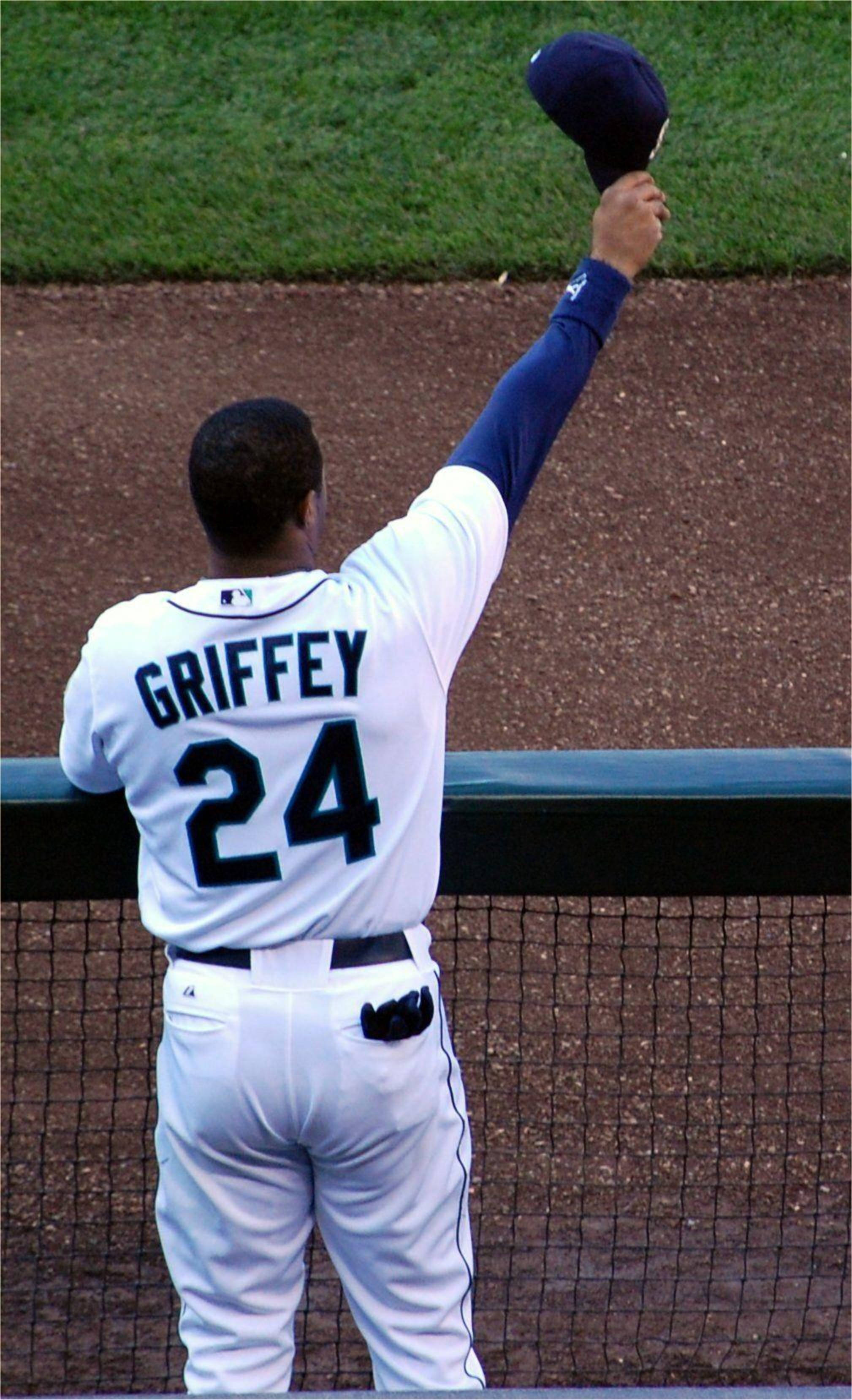 ken 桌布 壁紙 — 一名身穿白色GriffeY 24球衣的棒球選手在球場的圍欄後舉起帽子表示致意。