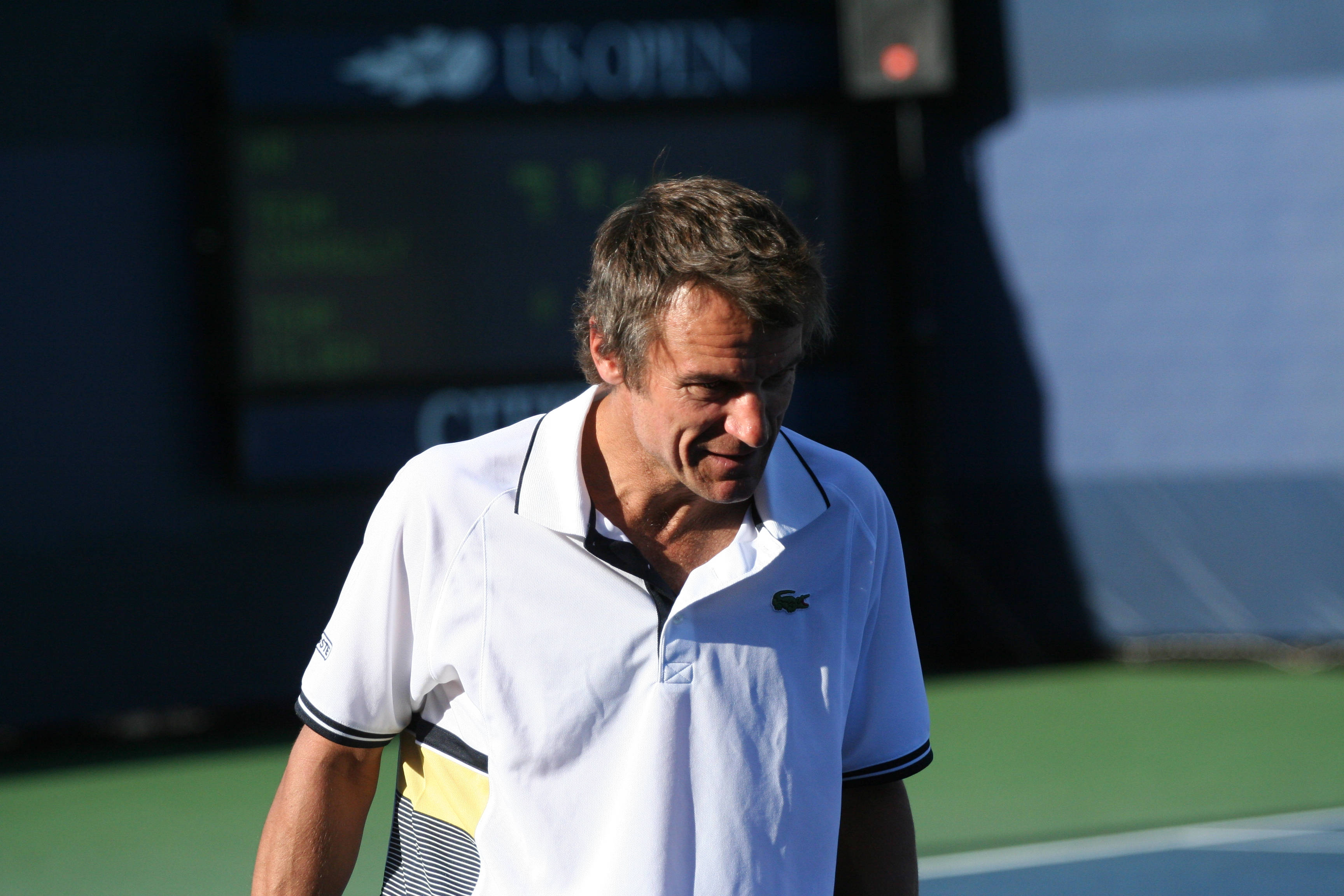 Tennis 桌布 壁紙 — 一名身穿白色Polo衫的男網球運動員在明亮的日光下，在綠色球場上顯得沮喪。