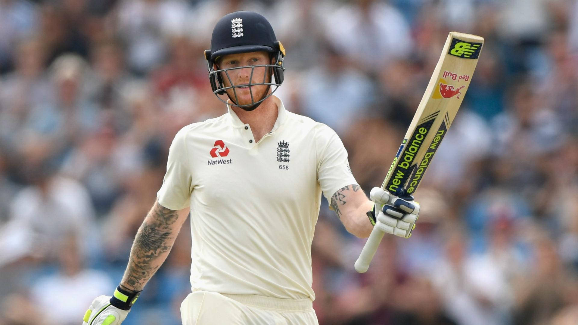Ben Stokes 桌布 壁紙 — 一名身穿白色制服和頭盔的板球運動員自信地走著，手持球棒，背景有群眾。