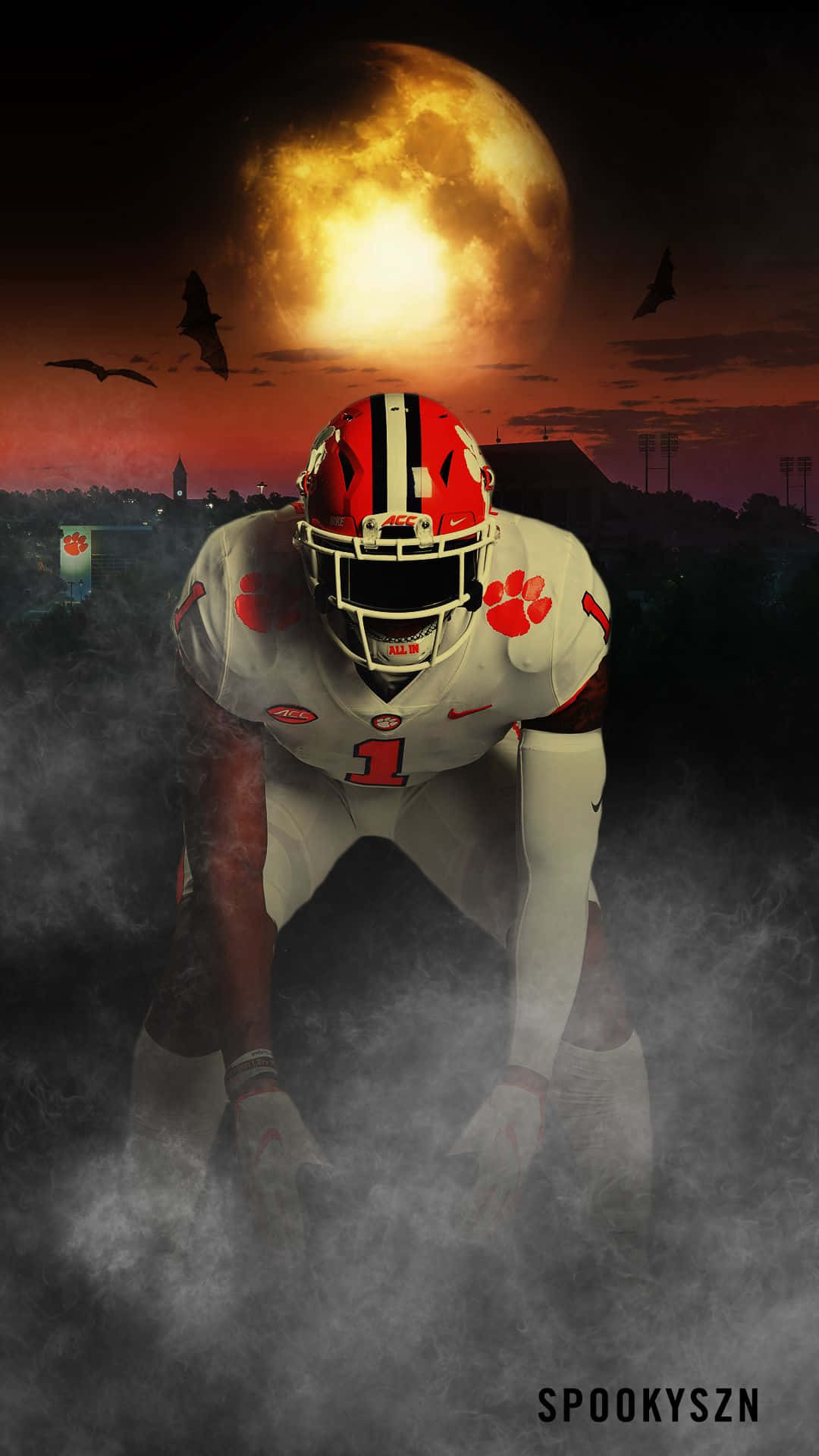 Clemson iPhone 桌布 壁紙 — 一名身穿白色和橙色球衣的足球員在霧中蹲下，頭頂上有一輪巨大的發光月亮，蝙蝠在飛翔。