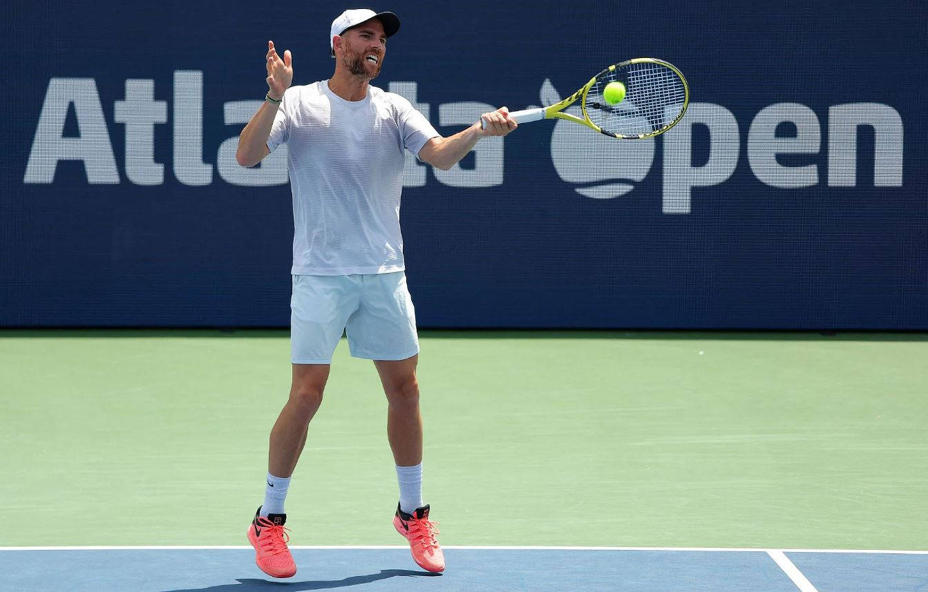 Tennis 桌布 壁紙 — 一名身穿白色和粉紅色裝備的男網球選手在亞特蘭大公開賽的亮綠色球場上正手擊球。