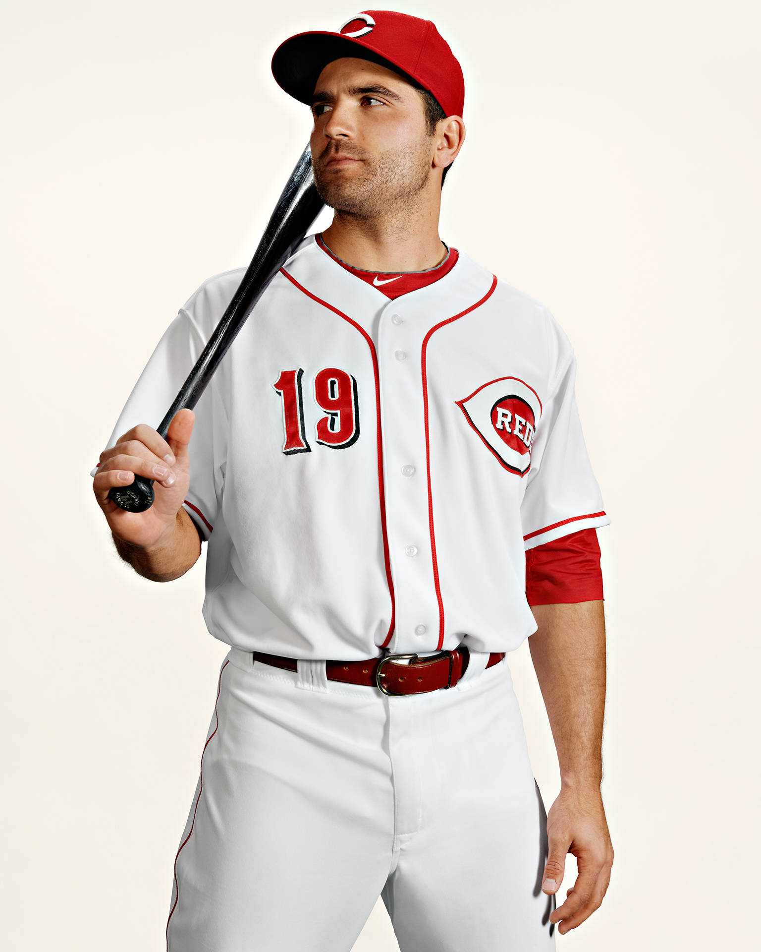Joey Votto 桌布 壁紙 — 一名身穿白色和紅色制服、背號19的棒球選手，在純色背景前手持球棒。