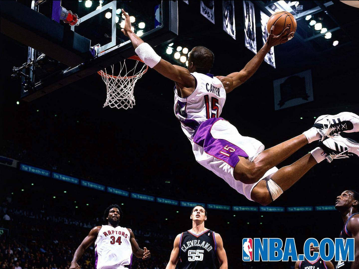 NBA 桌布 壁紙 — 一名身穿白色和紫色球衣的籃球運動員在明亮的場館燈光下，專注地飛身灌籃。