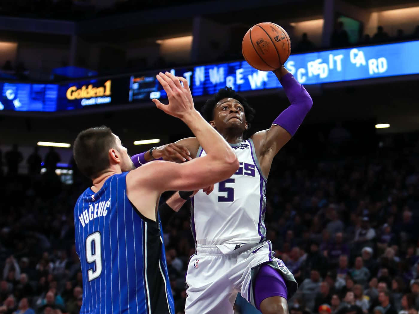 NBA 桌布 壁紙 — 一名身穿白色和紫色球衣的籃球運動員在藍色條紋球衣的防守球員防守下投出跳投。