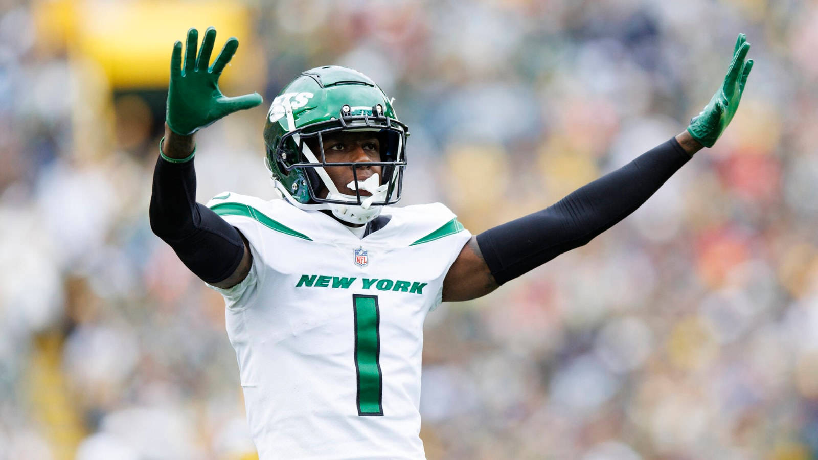 Ny Jets 桌布 壁紙 — 一名身穿白色和綠色球衣的紐約噴射機美式足球員在陽光明媚的比賽日高舉雙臂慶祝。