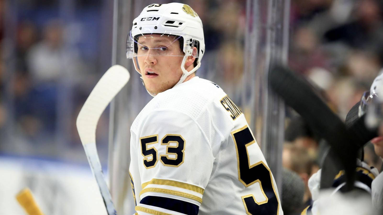 hockey 桌布 壁紙 — 一名身穿白色和金色球衣、號碼53的冰上曲棍球運動員在冰上專注地回頭看。