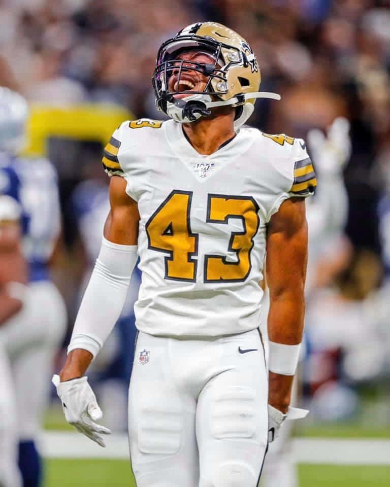 Marcus Williams 桌布 壁紙 — 一名身穿白色和金色球衣的43號美式足球員在燈光球場上張開嘴巴慶祝。