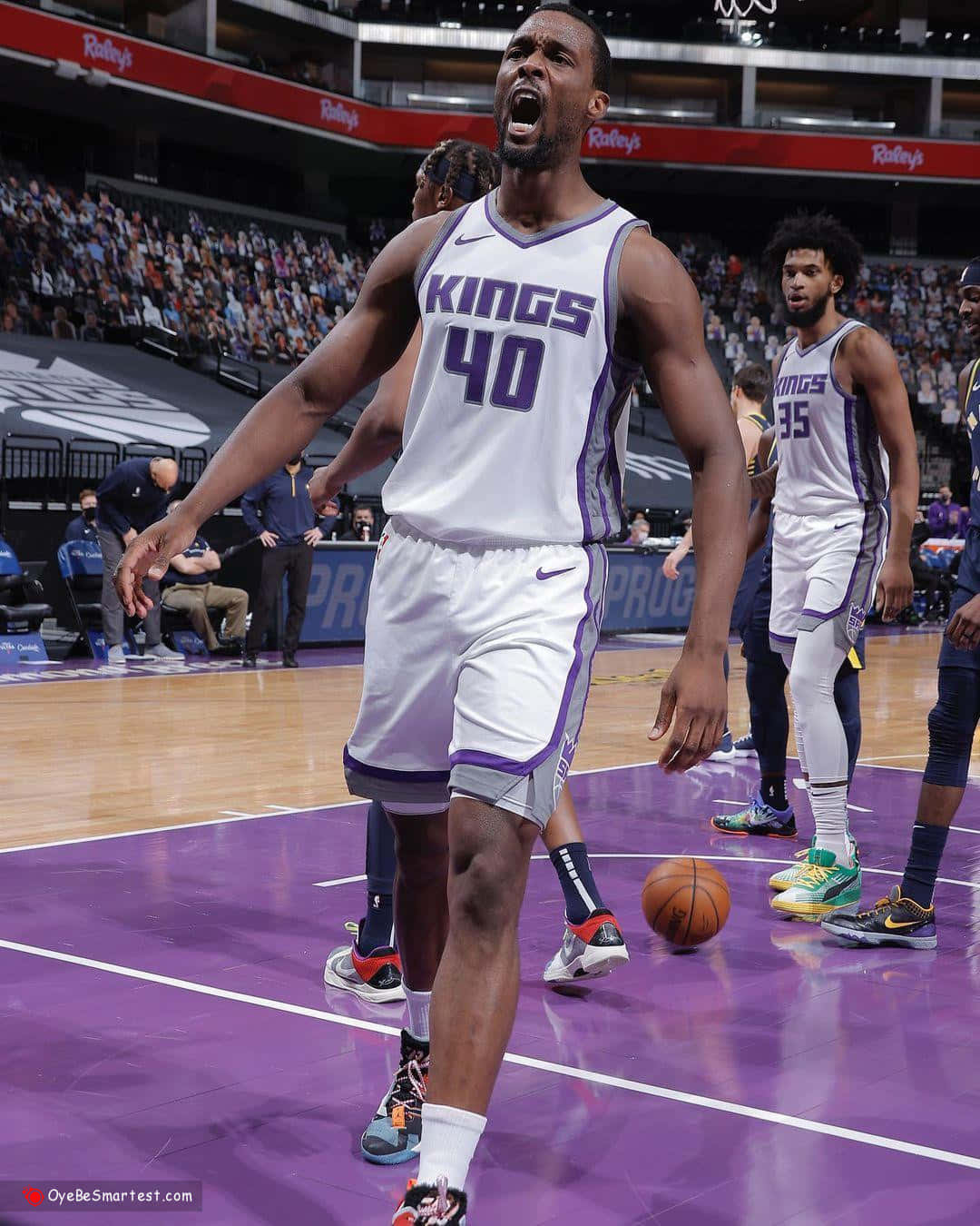 NBA 桌布 壁紙 — 一名身穿白色國王隊40號球衣的籃球運動員在紫色球場上比賽時激烈咆哮。