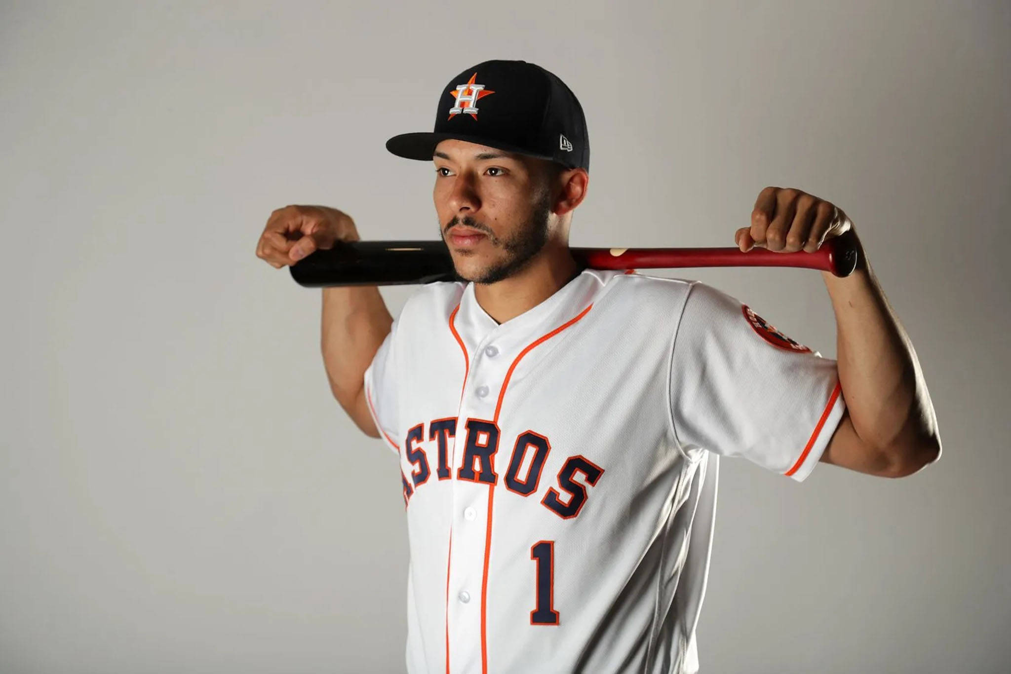Carlos Correa 桌布 壁紙 — 一名身穿白色太空人球衣、背號1號的棒球選手，在純灰色背景前將球棒扛在肩上。