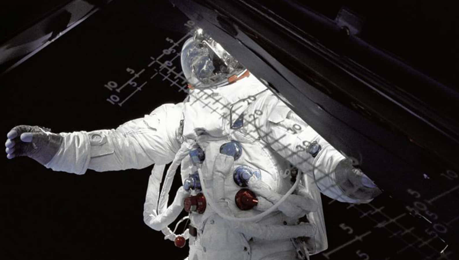 Moon Landing 桌布 壁紙 — 一名身穿白色太空衣的太空人漂浮在太空船外，背景是漆黑的太空，可見網格線。