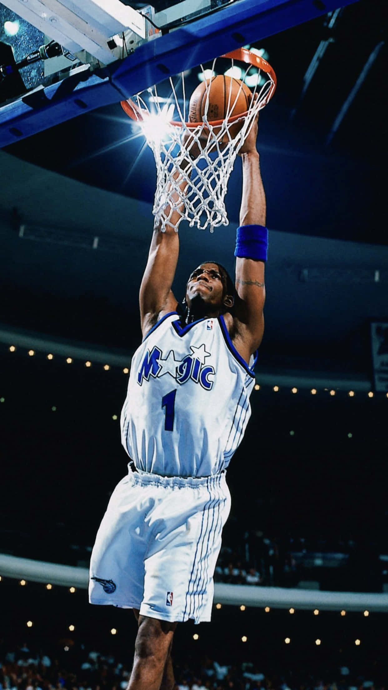 Tracy Mcgrady 桌布 壁紙 — 一名身穿白色奧蘭多魔術隊球衣的籃球運動員，在明亮的場館燈光下專注地灌籃。