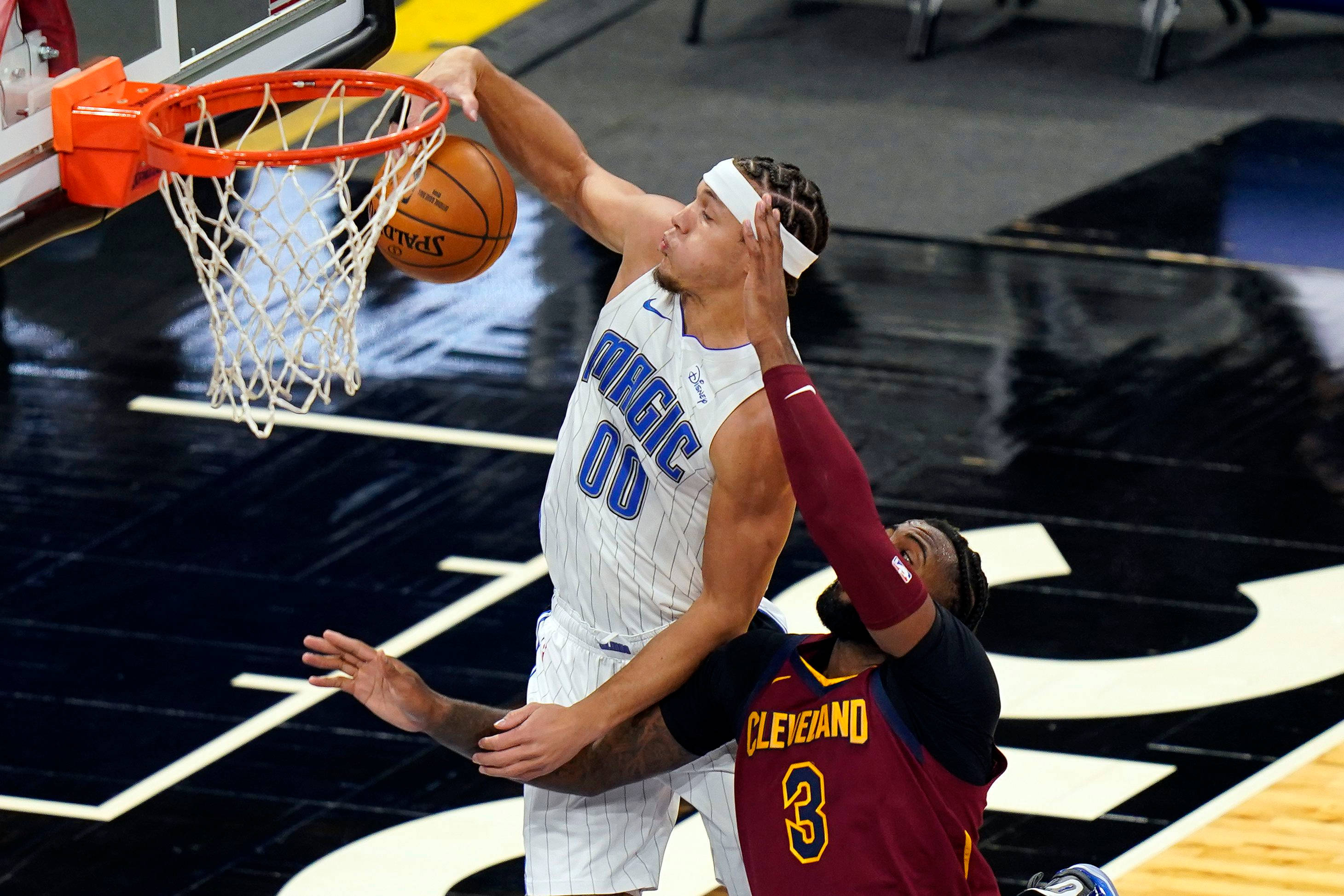 aaron gordon 桌布 壁紙 — 一名身穿白色奧蘭多魔術隊球衣的籃球運動員正在灌籃，而一名身穿酒紅色的克里夫蘭騎士隊防守球員試圖封阻。