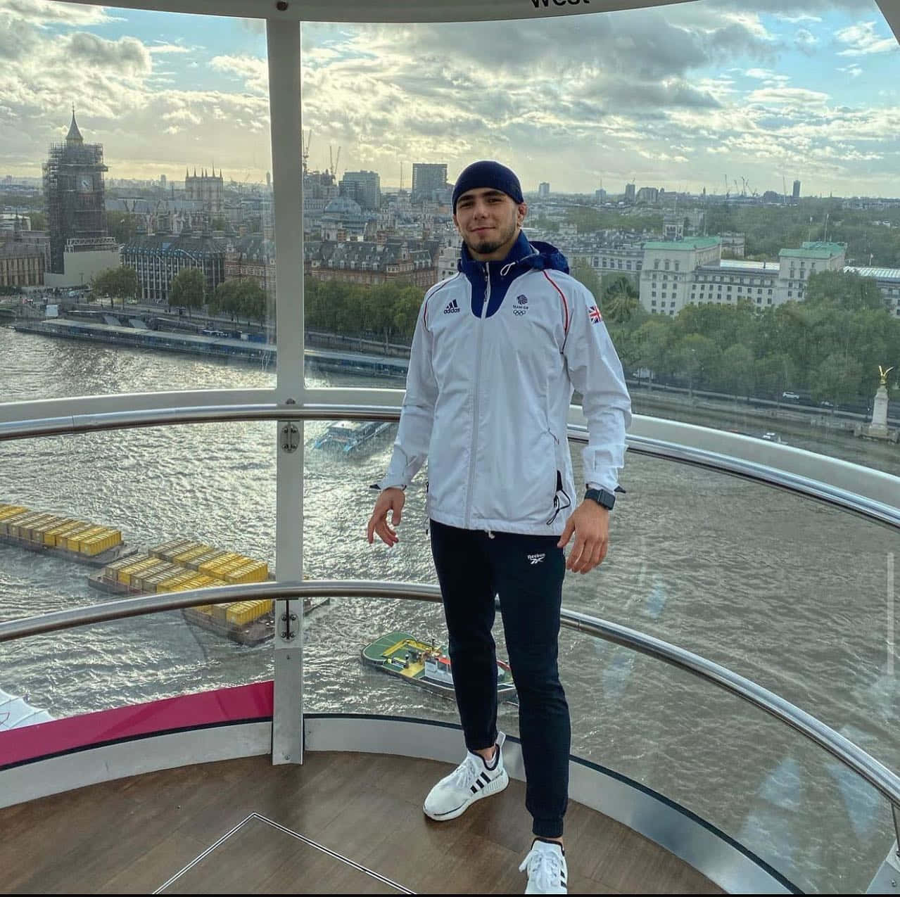 Athlete 桌布 壁紙 — 一名身穿白色奧運外套的男子站在倫敦眼觀景台上，俯瞰泰晤士河，遠處可見大笨鐘。